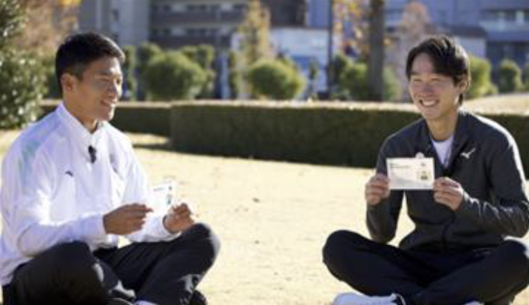 Shinji Hazawa and Masamichi Imamura holding RDD awareness cards